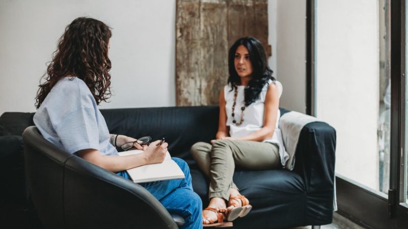 woman and therapist talking on a couch