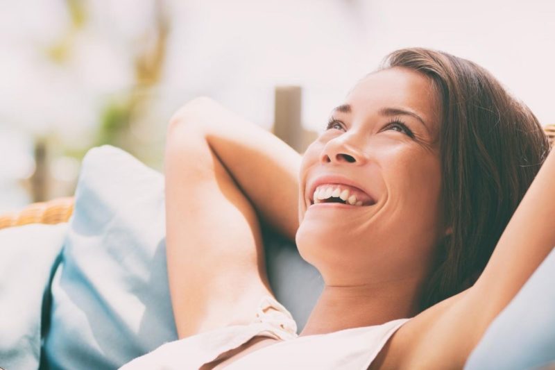 A woman relaxes on the couch as she enjoys her new sober living program.