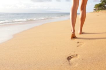 woman walks along beach at drug rehab provided by cigna rehab coverage