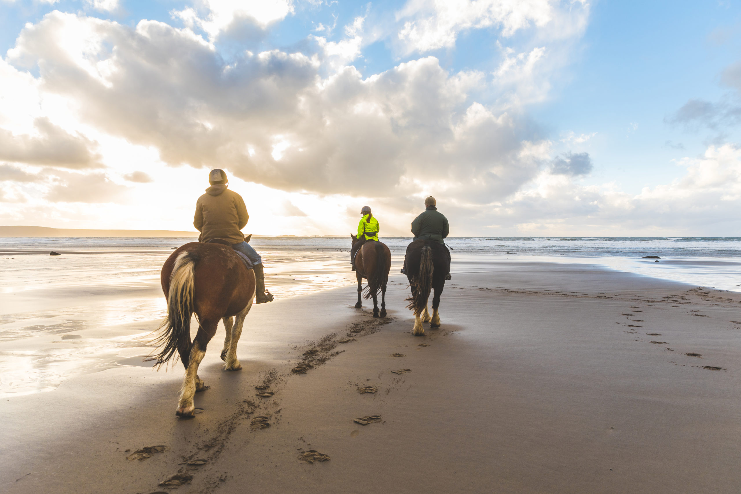 People horse riding on the beach