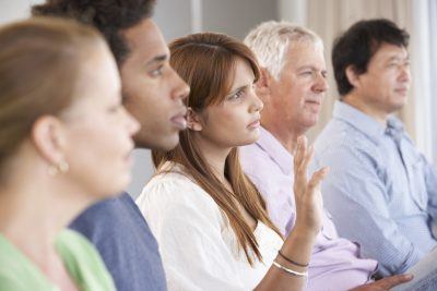 woman raising her hand in therapy