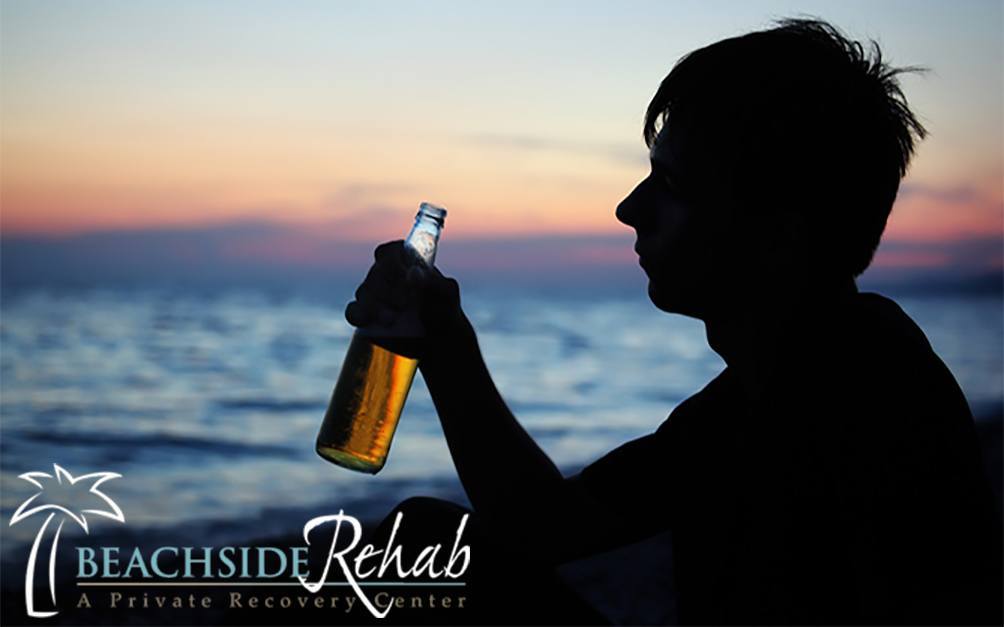 person drinking near the beach