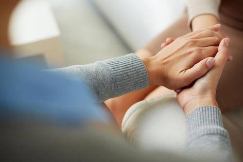 two women holding hands at Beachside Rehab's high-end treatment center