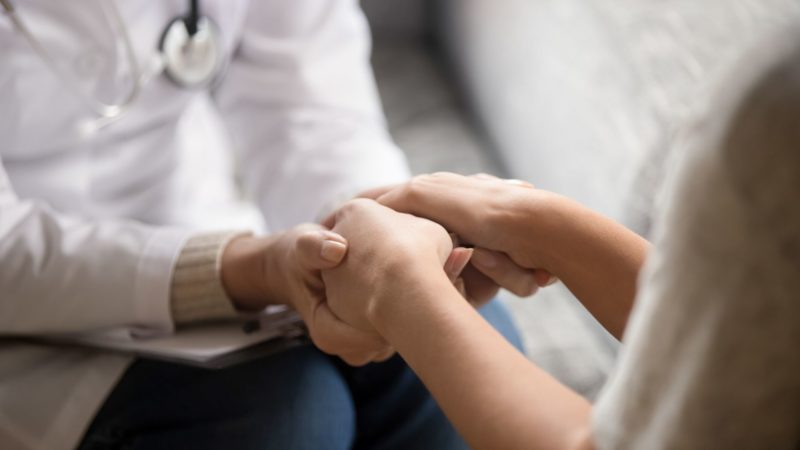 a doctor holding a patients hand