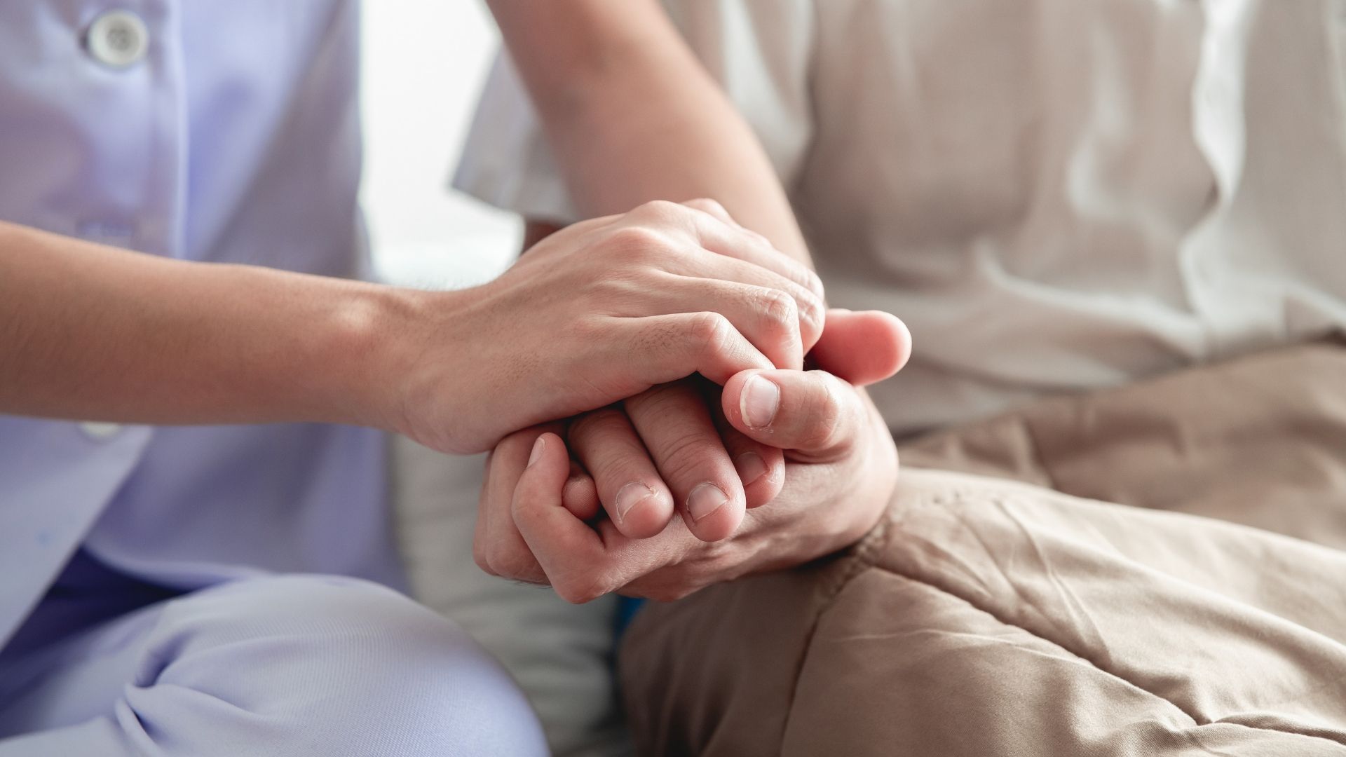 counselor and patient holding hands