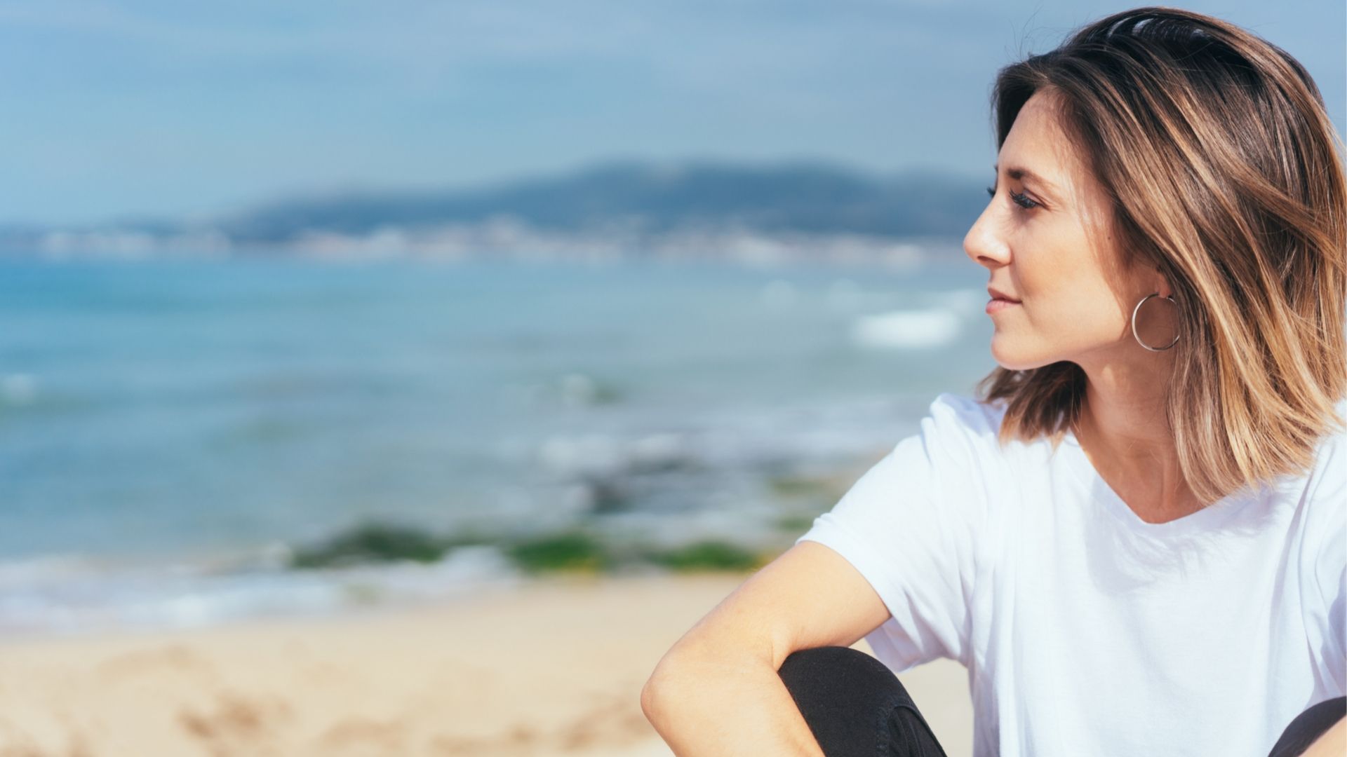 woman smiling looking over the beach