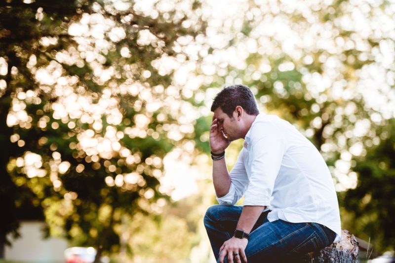 man holding head on stump