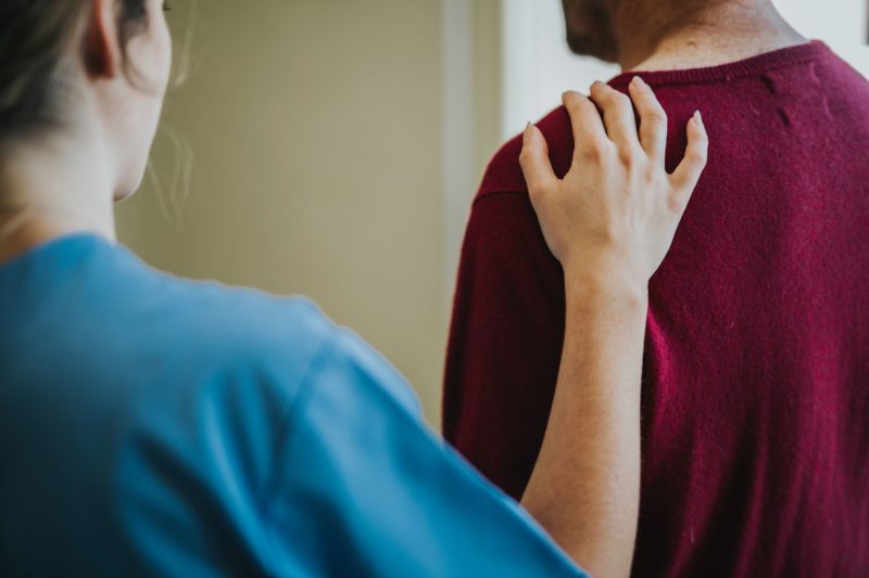 nurse with hand on patient shoulder