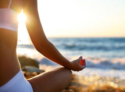 woman meditating on the beach