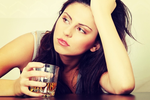 distraught woman with drink before entering alcohol rehab in texas