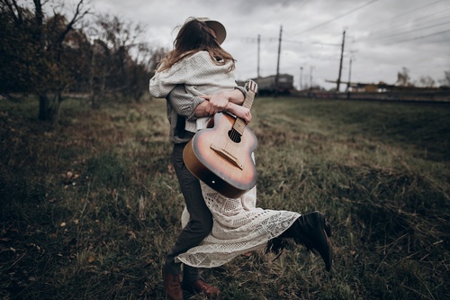 man and woman with guitar hugging at the best texas drug and alcohol treatment center