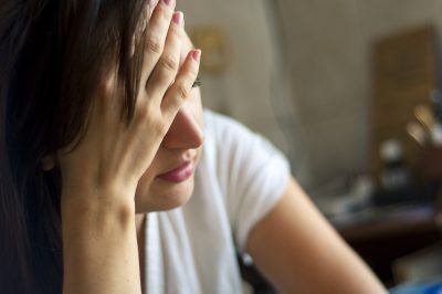 woman with hand on her head after a relapse 