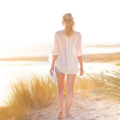 woman walking through beach grass on the beach