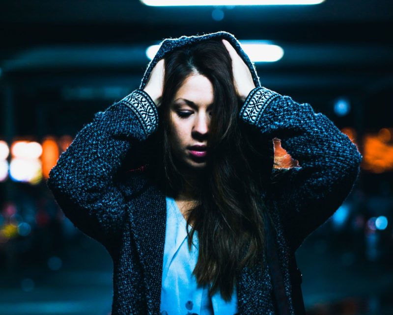woman standing with hands on head
