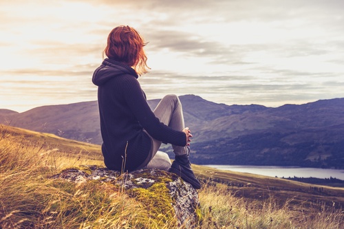 lady sitting on hill after going through the best roxy addiction treatment facility